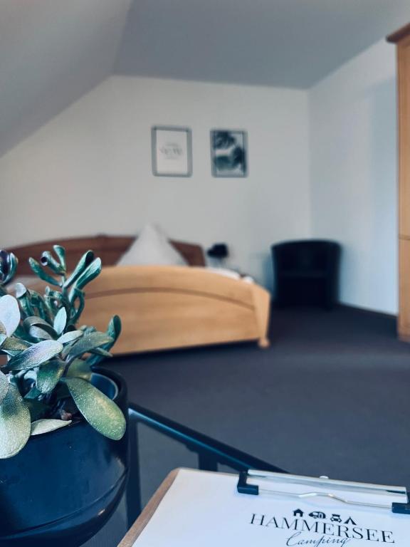 a bedroom with a bed and a potted plant on a table at Pension Lutter in Bodenwöhr