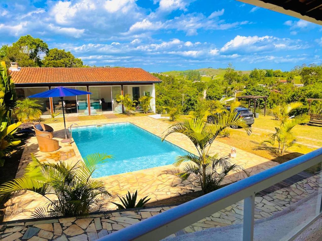 a swimming pool in a yard with a house at Chácara Coração no Mato in Santa Isabel