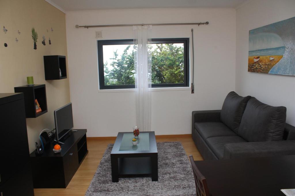 a living room with a couch and a table at Apartamento Mar e Sol in Ponta Delgada