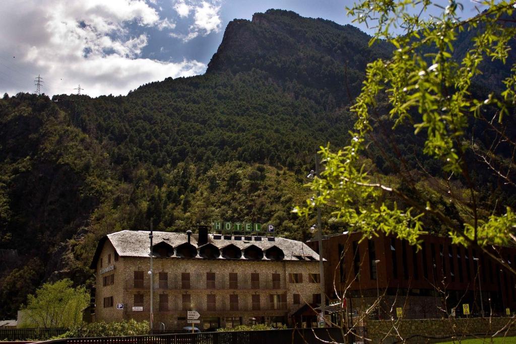 a large building with a mountain in the background at Hotel Barcelona in Aixovall