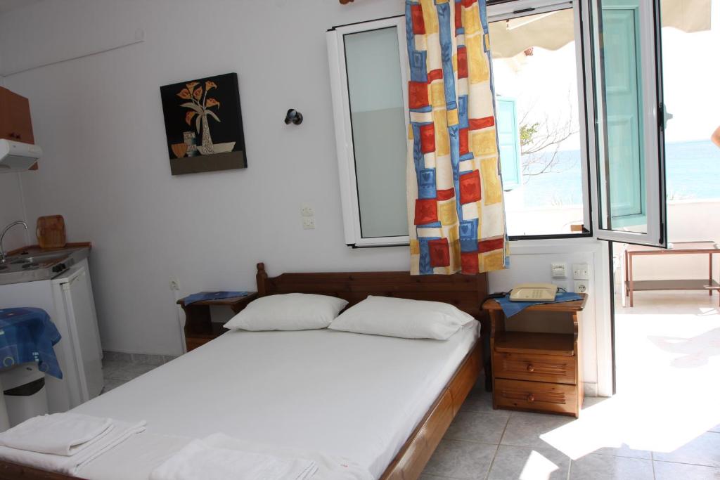 A bed or beds in a room at Akrogiali Hotel