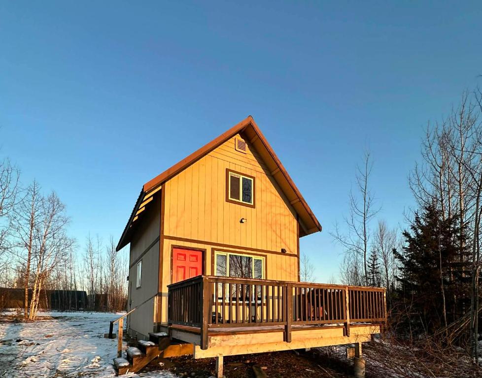 ein großes Holzhaus mit einer roten Tür in der Unterkunft The Northern Lights Oasis in Wasilla