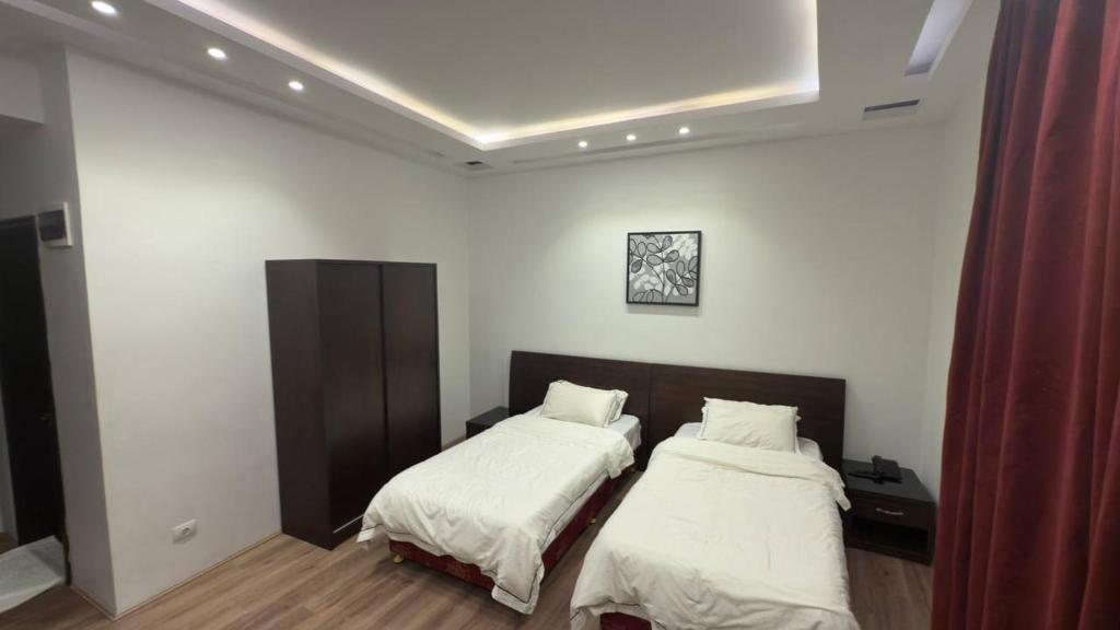 的黎波里فندق الجرات的一间白墙房间里有两张床