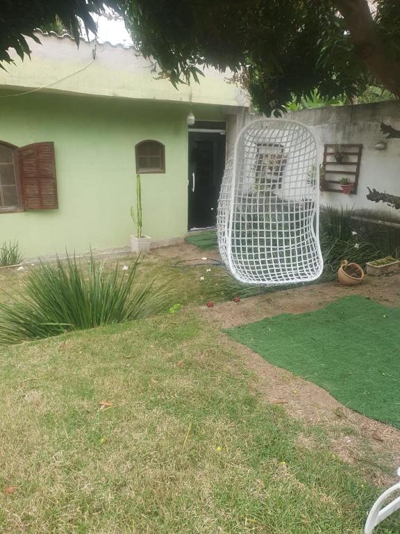 a white chair sitting in front of a house at Quarto privativo em Araruama in Araruama