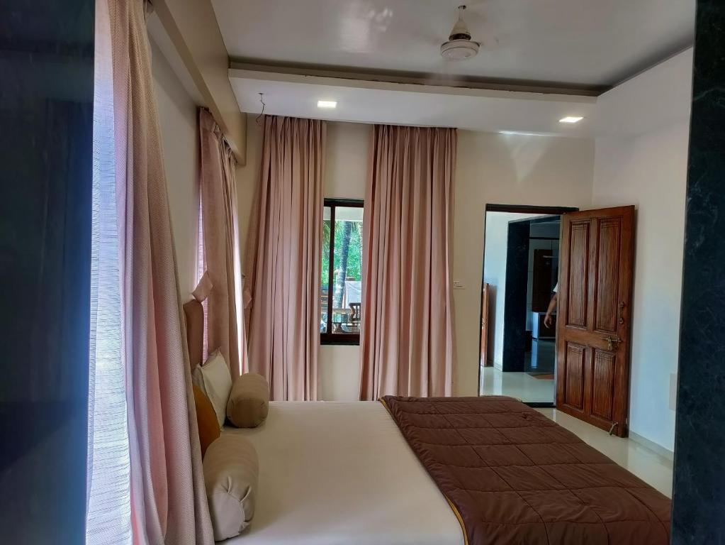 ein Schlafzimmer mit einem großen weißen Bett mit rosa Vorhängen in der Unterkunft Coral Bay Villa in Jāmb