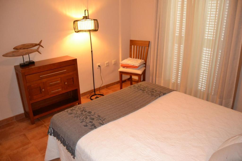 a bedroom with a bed and a dresser and a chair at Casa José in La Herradura