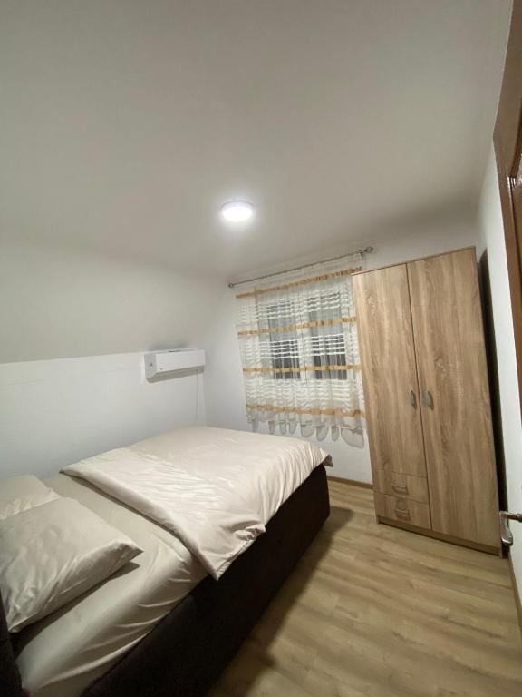 a bedroom with a bed and a wooden cabinet at Rakocevic house in Kolašin