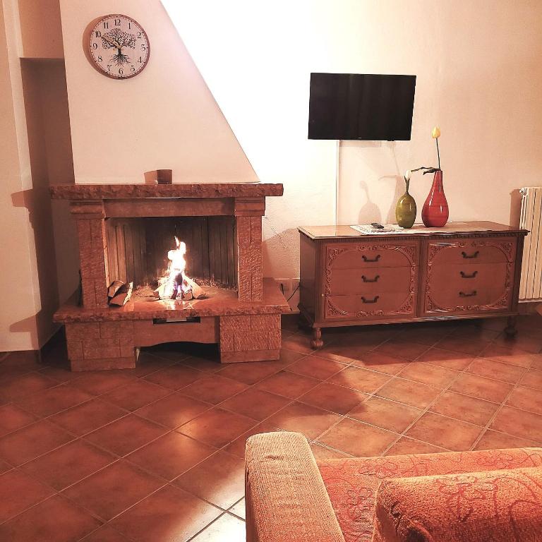 a living room with a fire in a fireplace at Il nido in montagna Mountain Lake Iseo Hospitality in Bossico