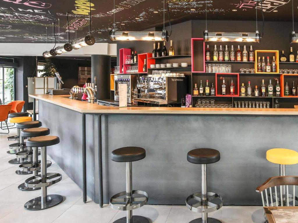eine Bar in einem Restaurant mit Hockern in der Unterkunft Ibis Styles Clermont-Ferrand République in Clermont-Ferrand