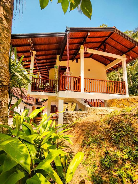 a house with a large deck on the side of it at Serene View Lodge in Unawatuna