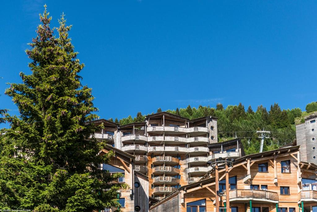 a large apartment building on a hill with a tree at Résidence Pierre & Vacances Atria-Crozats in Avoriaz