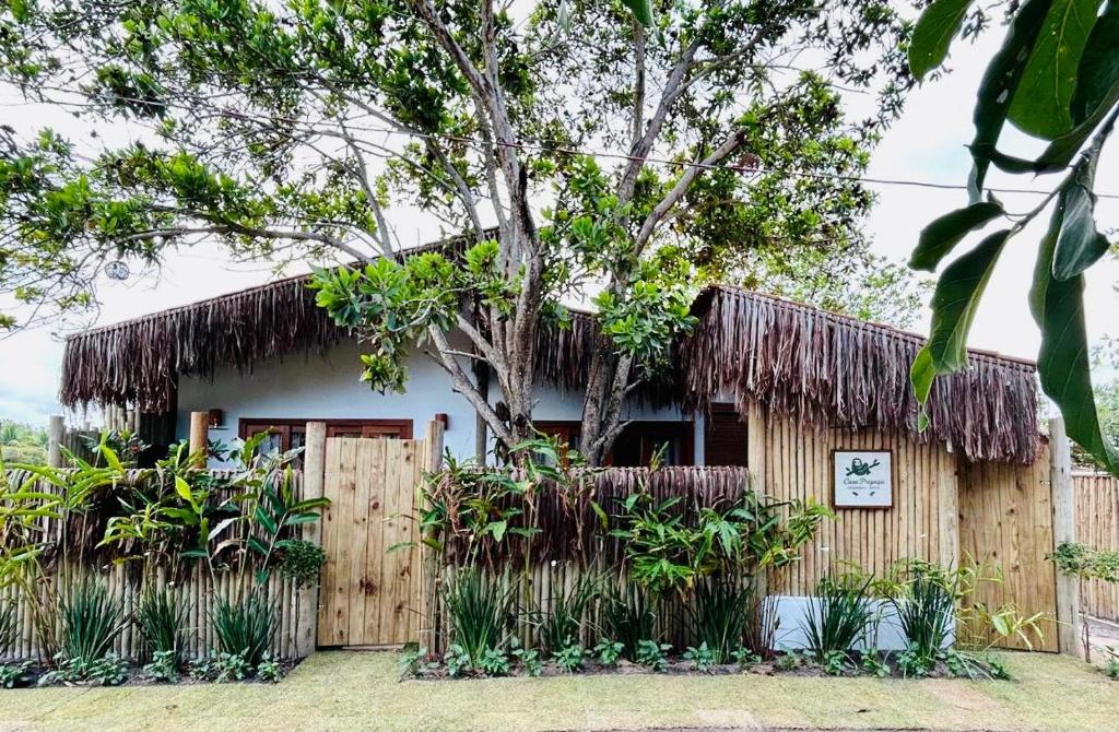 ein Haus mit einem Strohdach und einem Baum in der Unterkunft Casa Preguiça Corumbau in Corumbau