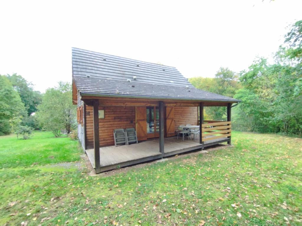 una baita di tronchi con terrazza in un campo di Gîte Chalet Morvan Bourgogne a Corancy