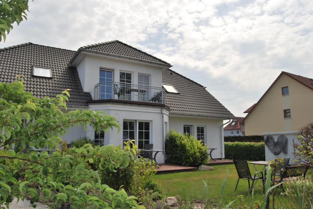 a white house with a black roof at Ferienhaus Kaptein Meyer in Zingst