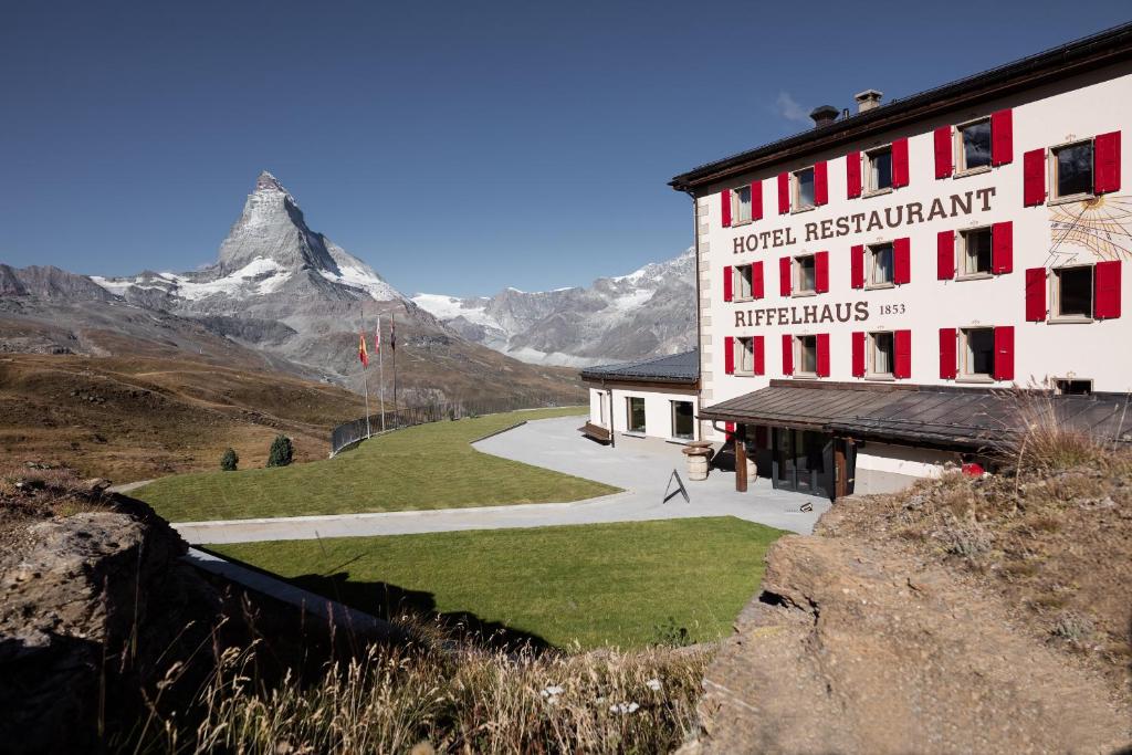 ein Gebäude mit einem Berg im Hintergrund in der Unterkunft Riffelhaus 1853 in Zermatt
