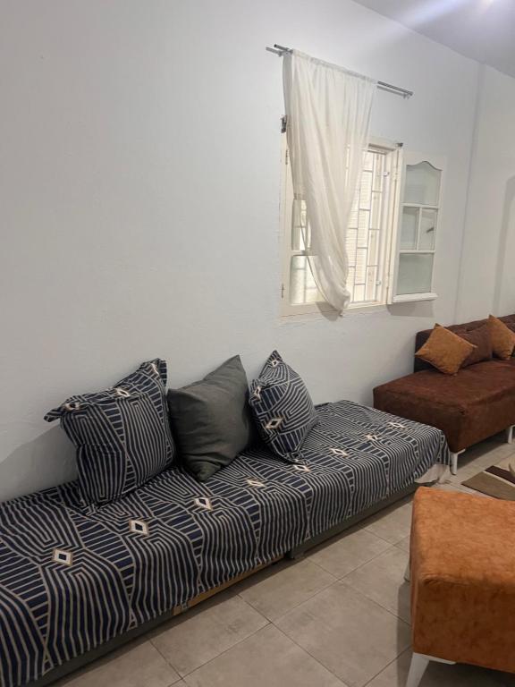 een bank in een woonkamer met een raam bij La coco in La Marsa