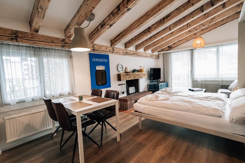 een slaapkamer met een bed, een tafel en stoelen bij LAAX Homes Casa Partnun 2-9 in Laax-Murschetg
