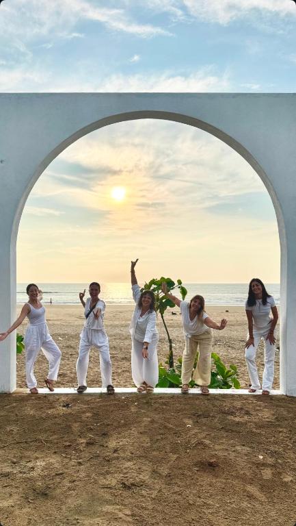 a group of women standing in an archway on the beach at Borrbo Beach Hostel Gokarna in Gokarna