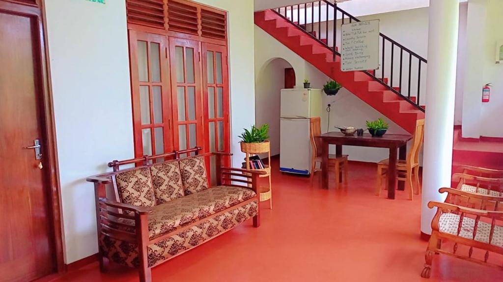 a living room with a couch and a staircase at Pravindi Guest Home in Mirissa