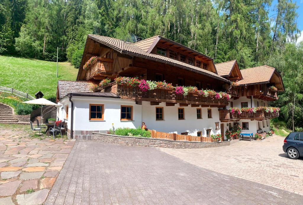 a house with flowers on the side of it at Leithäusl in San Lorenzo di Sebato