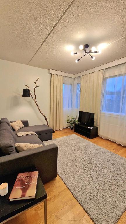 a living room with a couch and a television at Kotoisa Kaksio Levähdä Täällä ja Parkki in Lahti