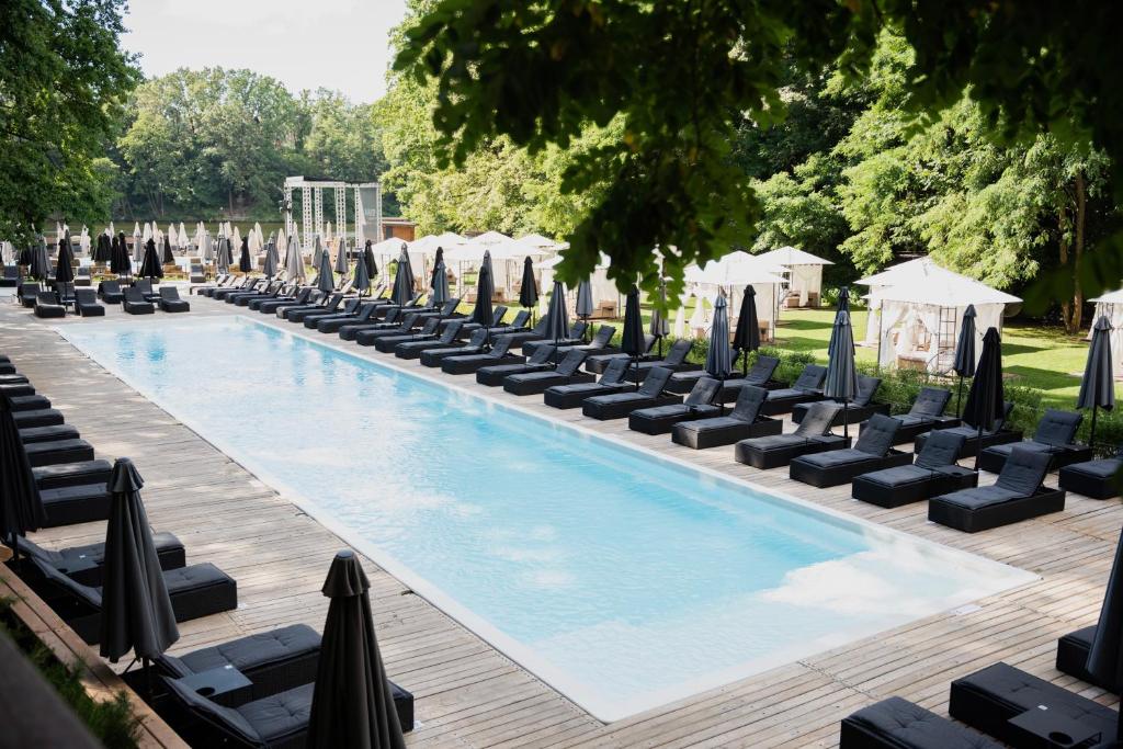 een zwembad met ligstoelen en parasols bij Характер парк in Hatne