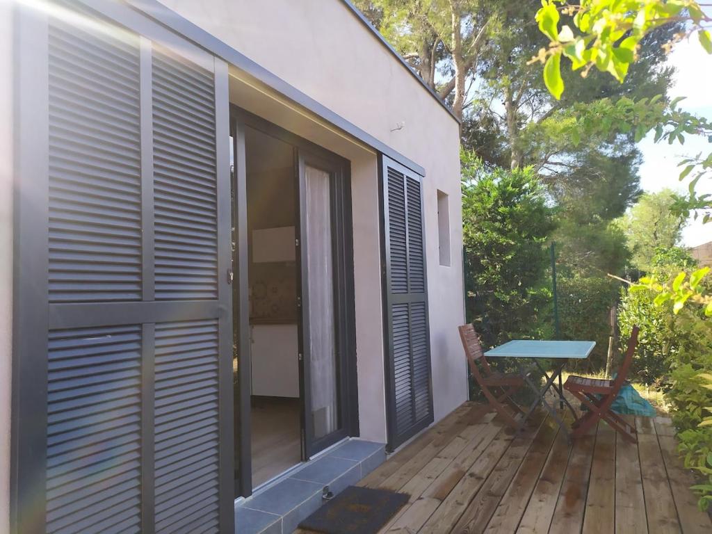 een patio met een tafel op een houten terras bij Studio terrasse au calme près de Narbonne in Narbonne