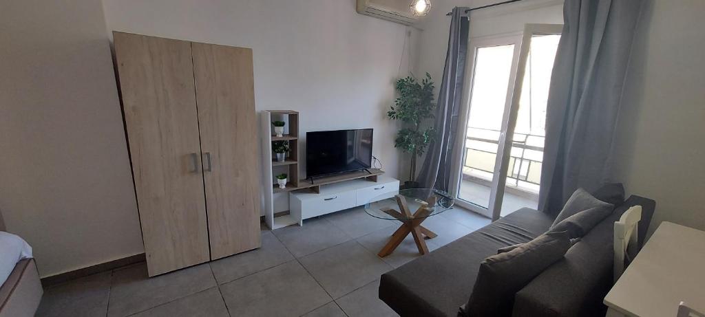 ein Wohnzimmer mit Sofa und Fernseher in der Unterkunft Helios nest in Artemida