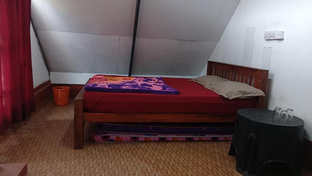 una piccola camera con un letto con una coperta rossa di Vattavada budget cottages & Aframe a Vattavada