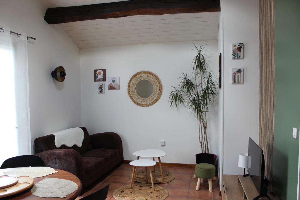 ein Wohnzimmer mit Sofa und Tisch in der Unterkunft La petite maison in Cuxac-Cabardès