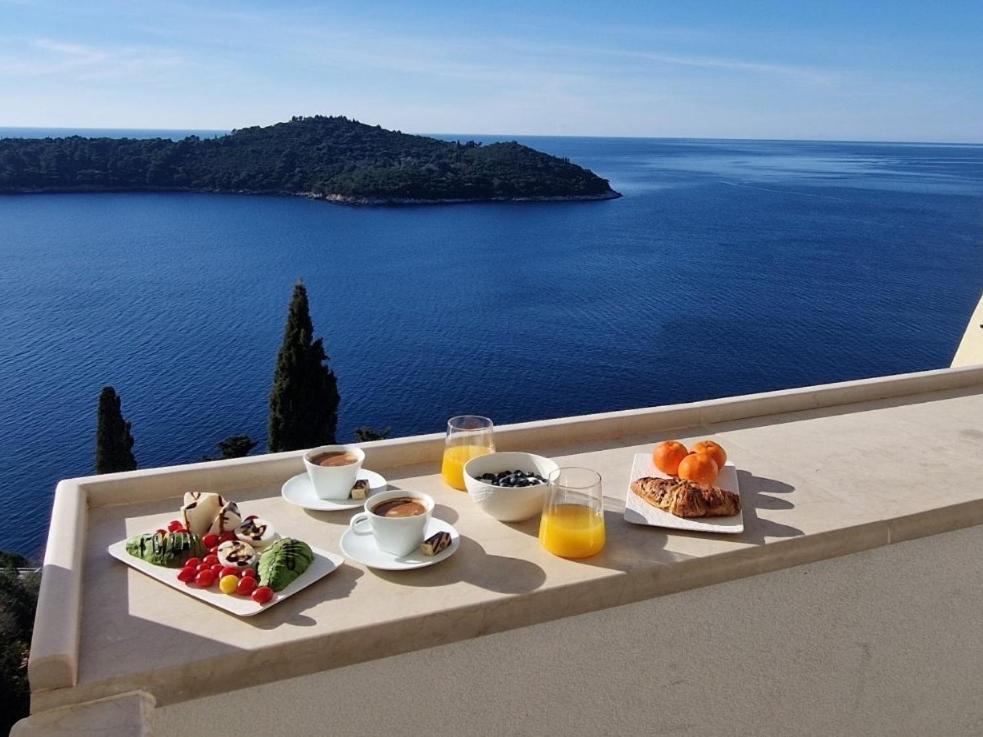 a tray of breakfast food on a table overlooking the ocean at Lacroma Apartment in Dubrovnik