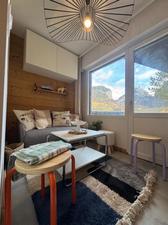 a living room with a couch and a table at Charming studio with balcony in Samoëns