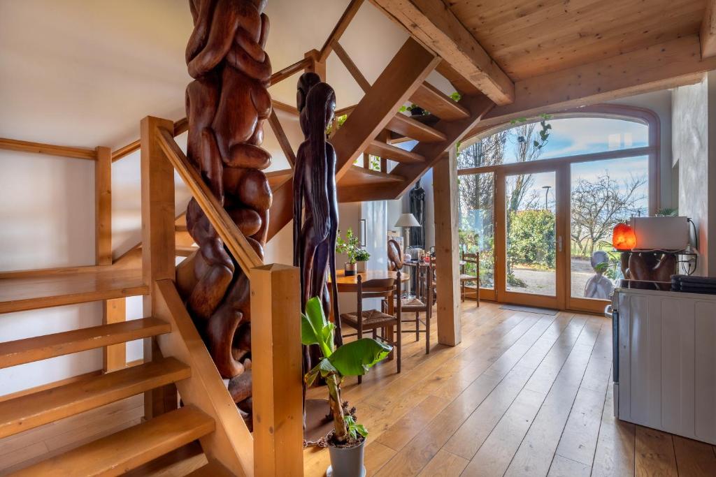 a living room with wooden stairs in a house at Séjour paisible près de Genève in Neydens