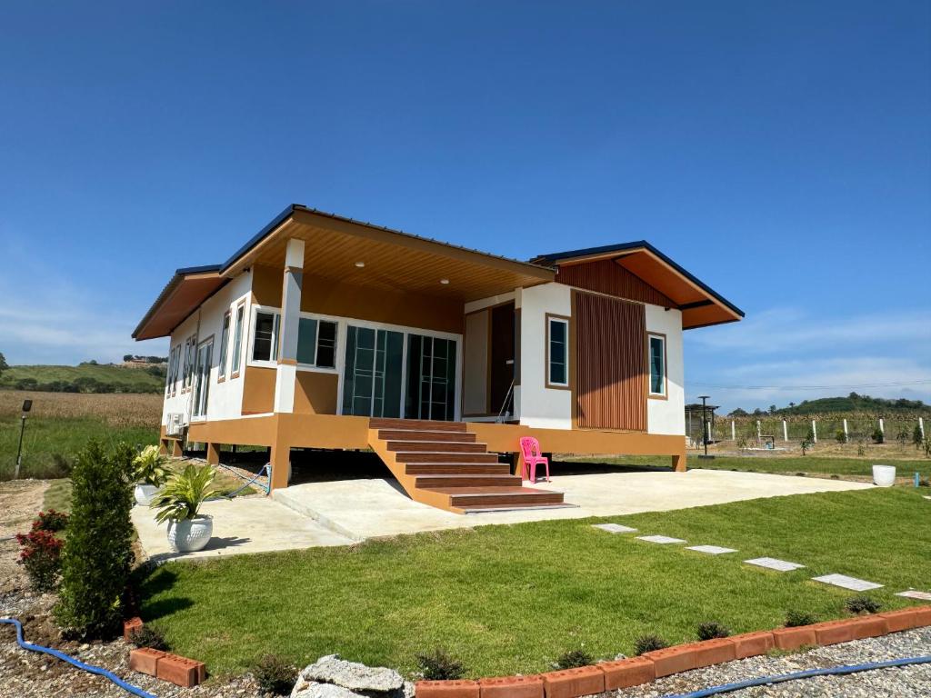 a small house with a lawn in front of it at บ้านไร่สกายดาว in Pak Chong