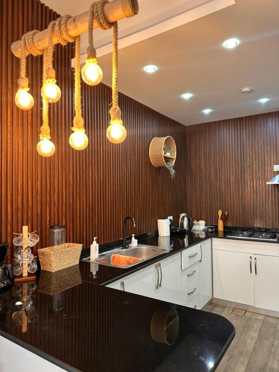 Lammah chalet في مسقط: مطبخ مع حوض ومكتب مع أضواء