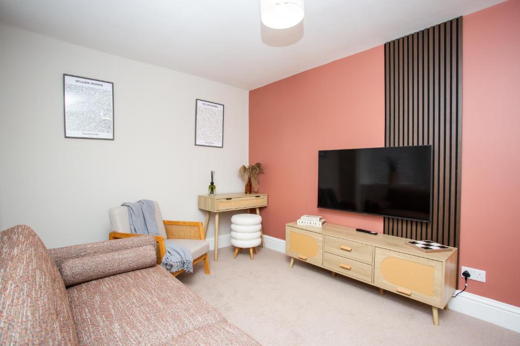 a living room with a couch and a flat screen tv at Vacant Nests The Allendale Central 3BR in Allendale Town