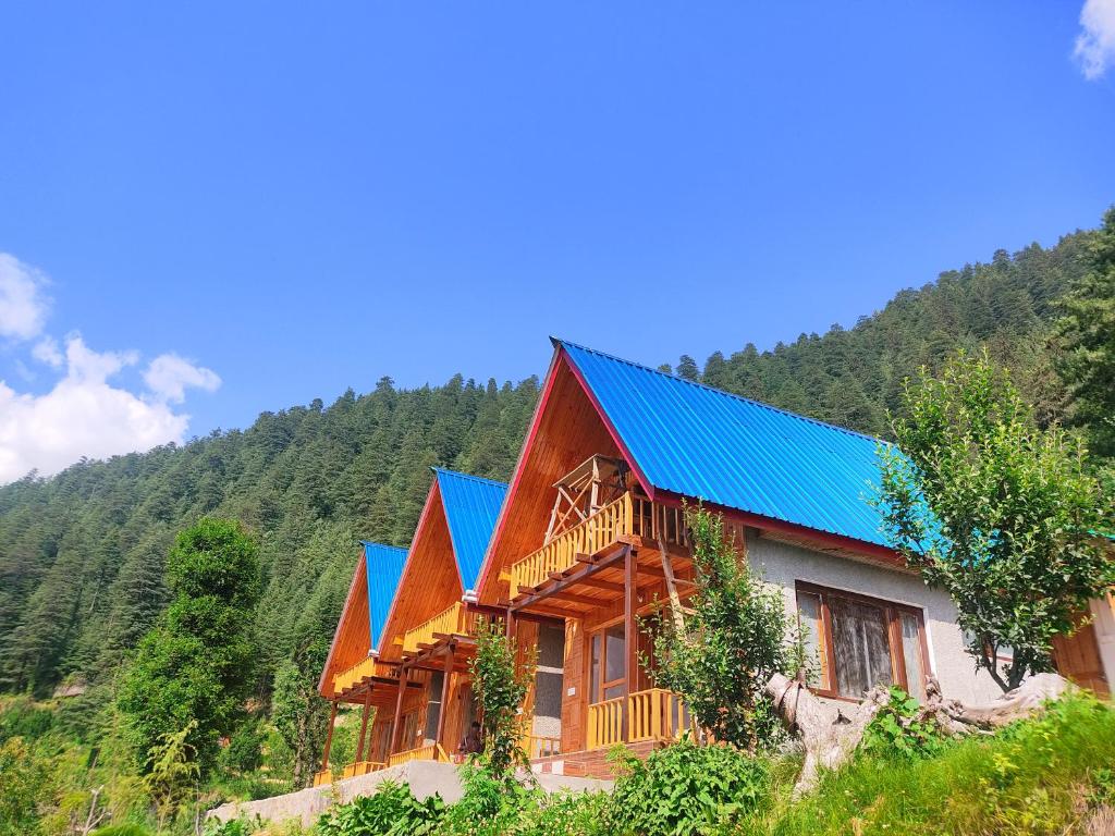 a large wooden house with a blue roof at A-Frame Cabins in Sainj