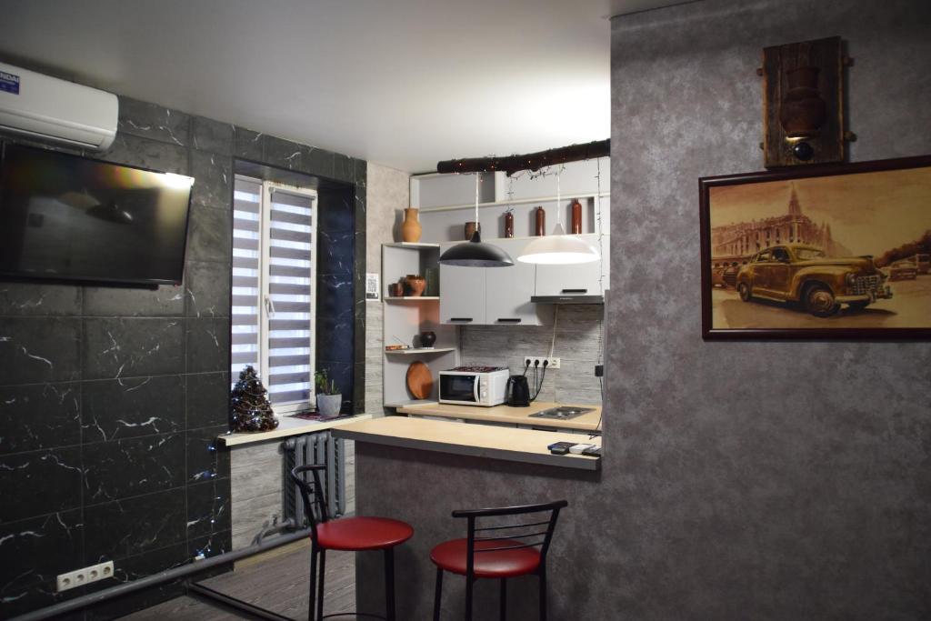 a kitchen with two stools and a counter with a microwave at Квартира - студія in Konotop