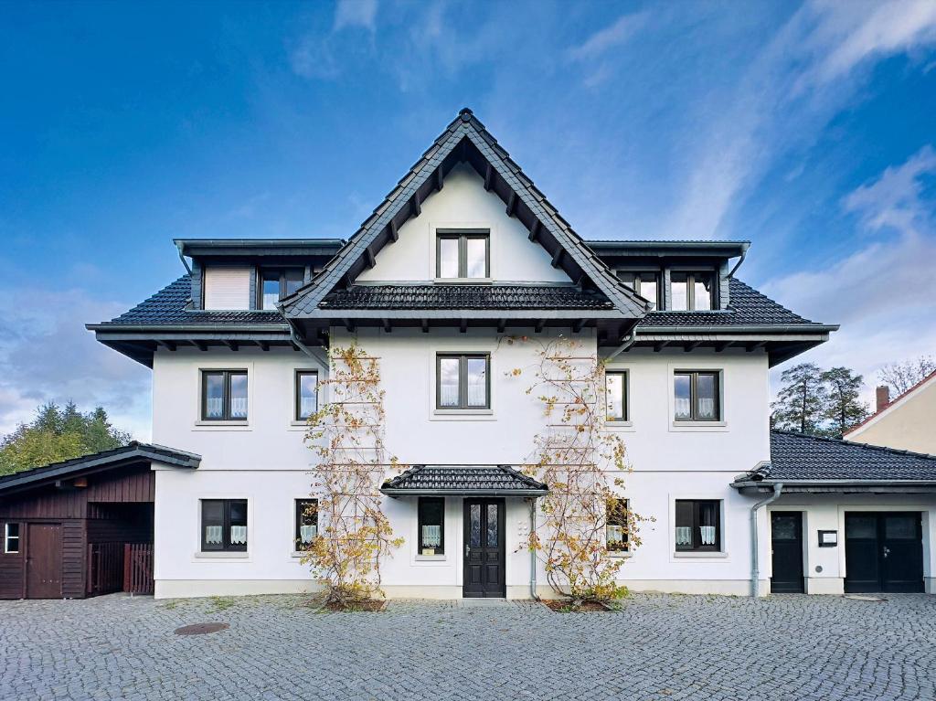ein weißes Haus mit einem schwarzen Dach in der Unterkunft Ferienhaus Kaiserhof in Markkleeberg