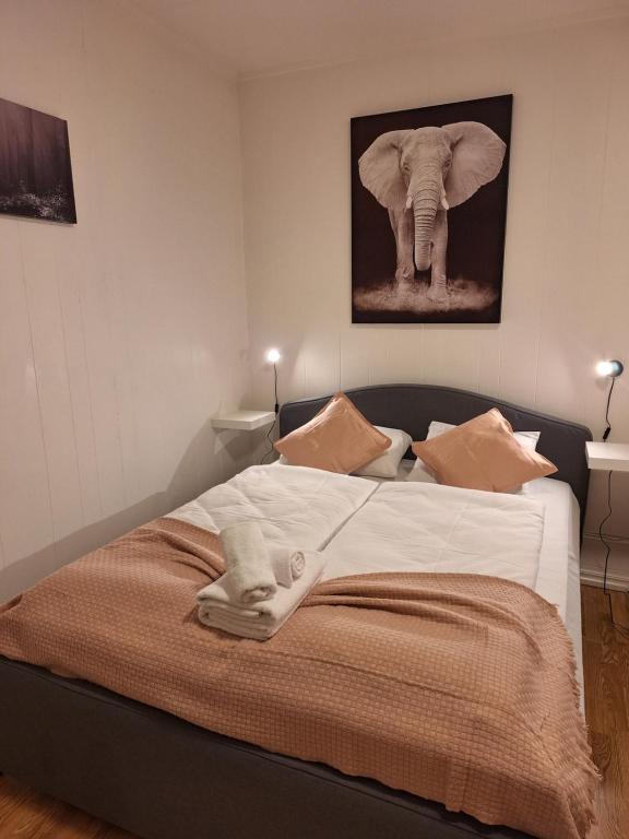 ein Schlafzimmer mit einem Bett mit einem Elefantenbild an der Wand in der Unterkunft Apartment 3 Sea Centrum Stavanger in Stavanger