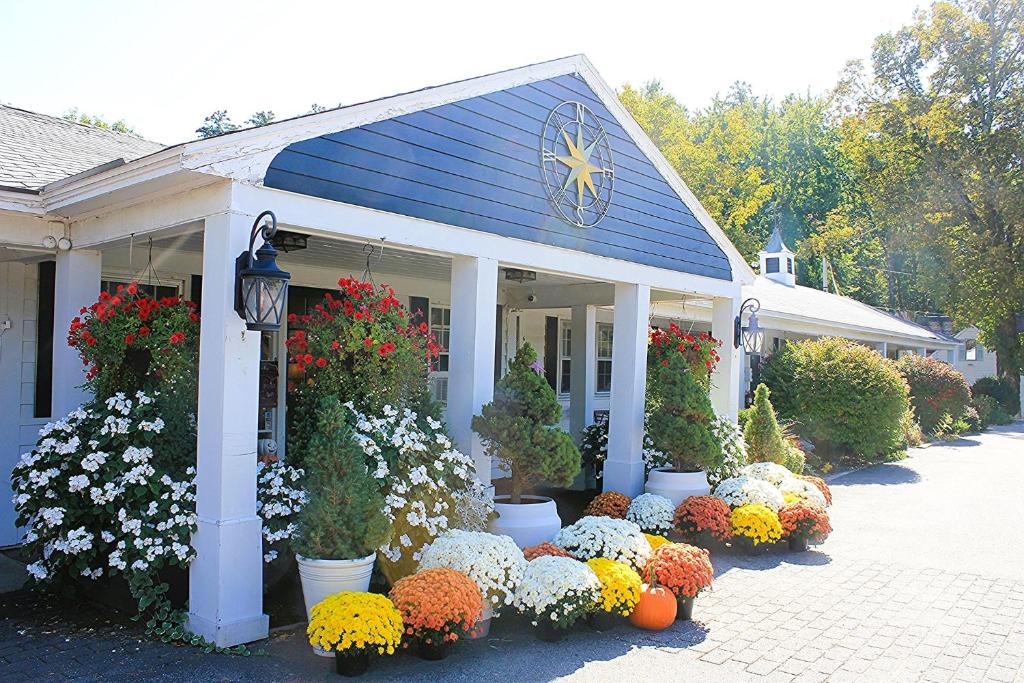 een tentoonstelling van bloemen voor een huis bij Scenic Vista Inn in North Conway
