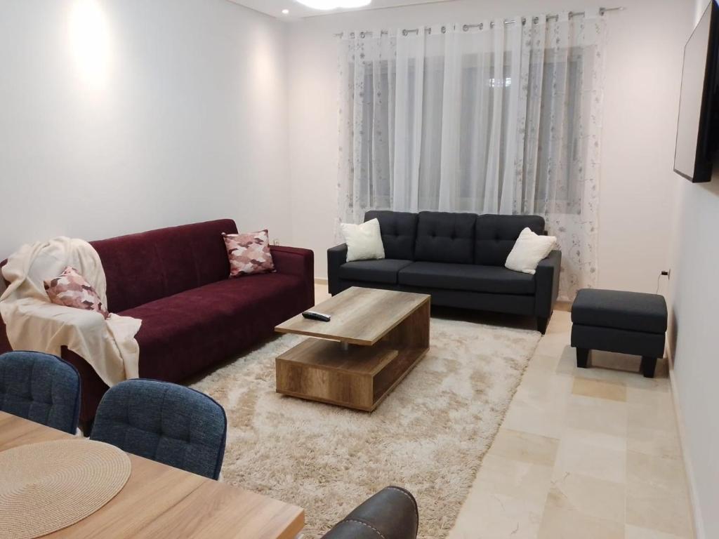 a living room with a couch and a coffee table at Les belles loges in Bouskoura