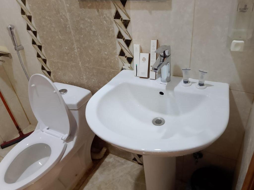 ein weißes Badezimmer mit Toilette und Waschbecken in der Unterkunft راحتي هنا 7 in Riad