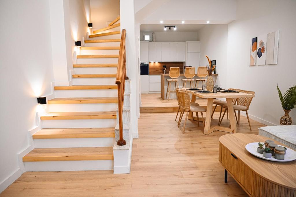 a staircase in a living room with a table and a kitchen at Portside Residence Piräus in Piraeus