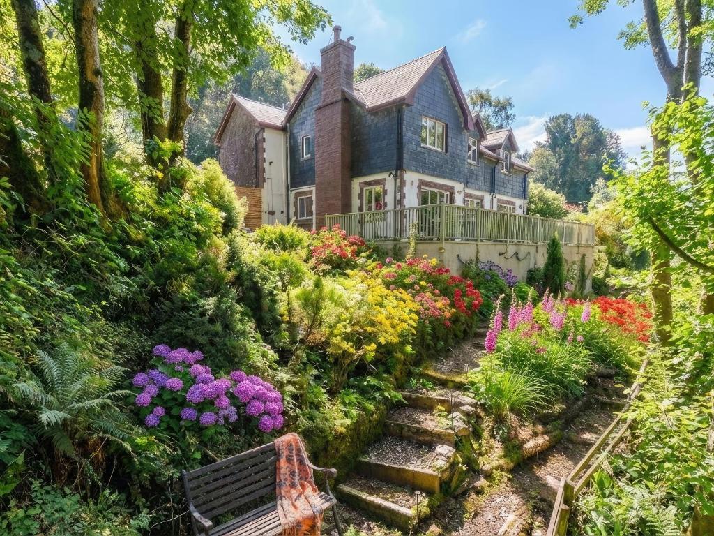 ein Haus mit einem Garten mit Blumen und einer Bank in der Unterkunft Bracken Lea in Barbrook