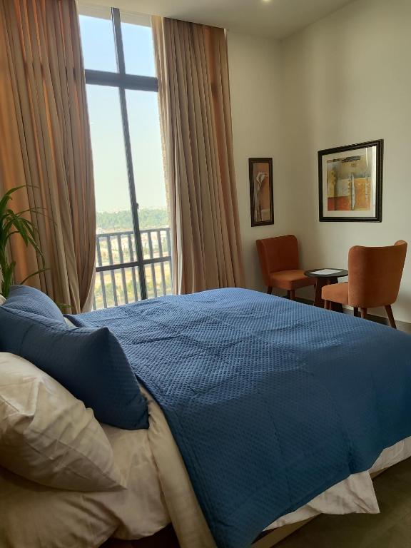 a bedroom with a blue bed and a window at Sky Park Nest in Islamabad