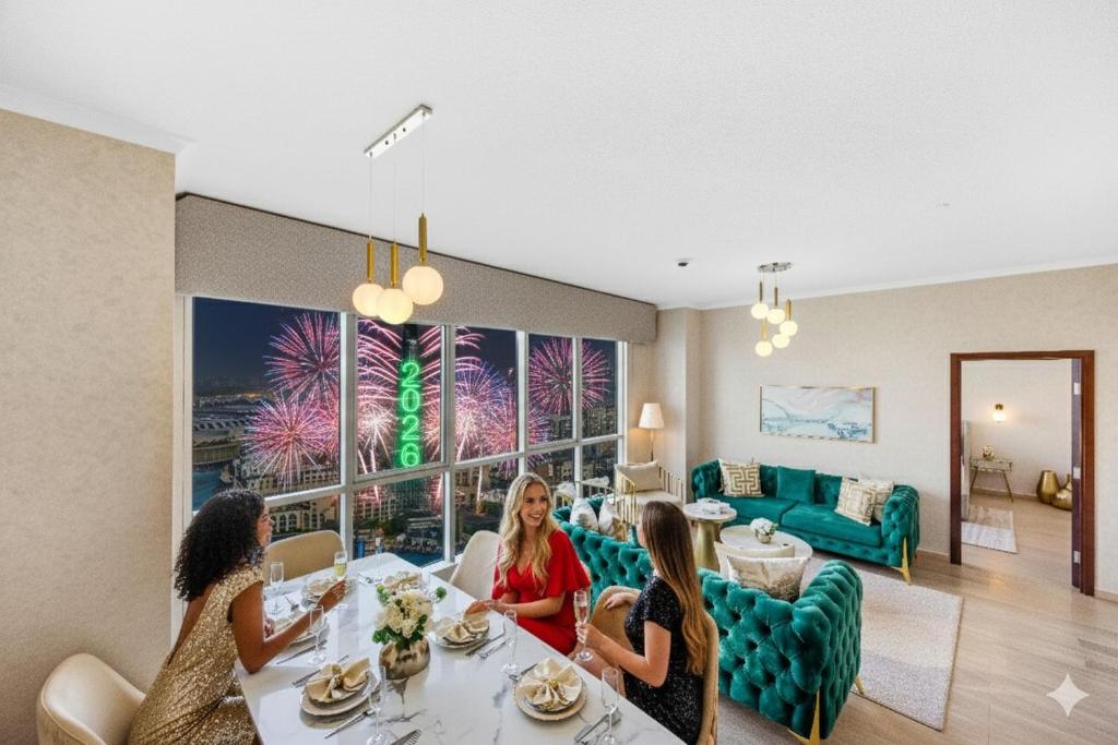 tre donne sedute a un tavolo in un soggiorno di Durrani Homes - Grand 5BR besides Burj khalifa and Fountain view a Dubai