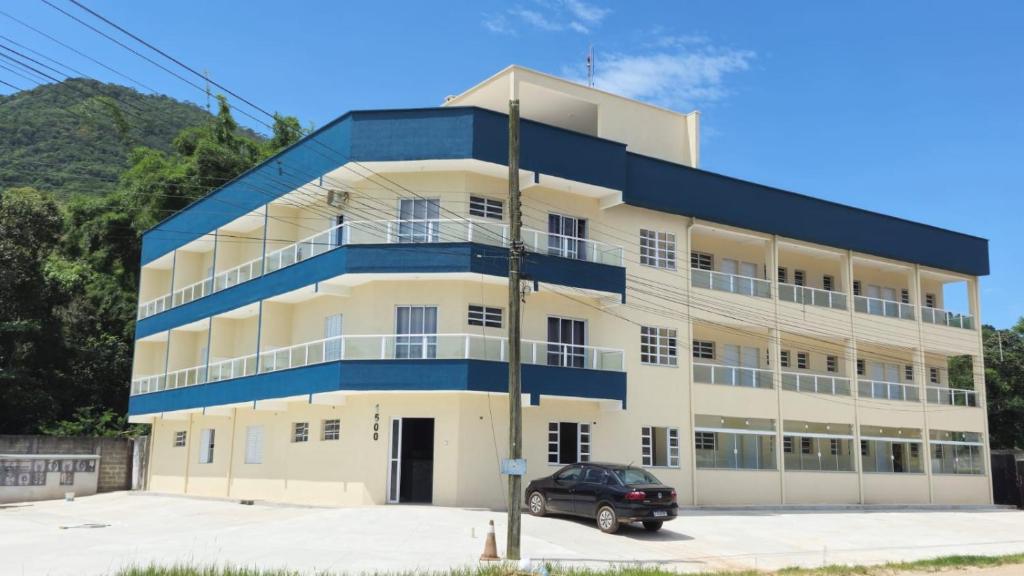 a building with a car parked in front of it at Recanto Ubaduba in Ubatuba