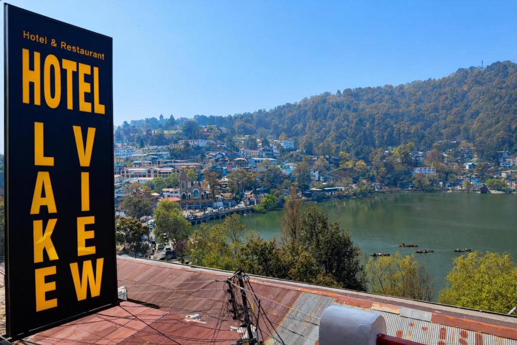 ein Schild auf einem Gebäude mit Blick auf einen See in der Unterkunft Hotel Naini -Lake -View Near The Mall Road - Restaurant And Free Wifi All Rooms - Prime Location - Best Hotel in Nainital