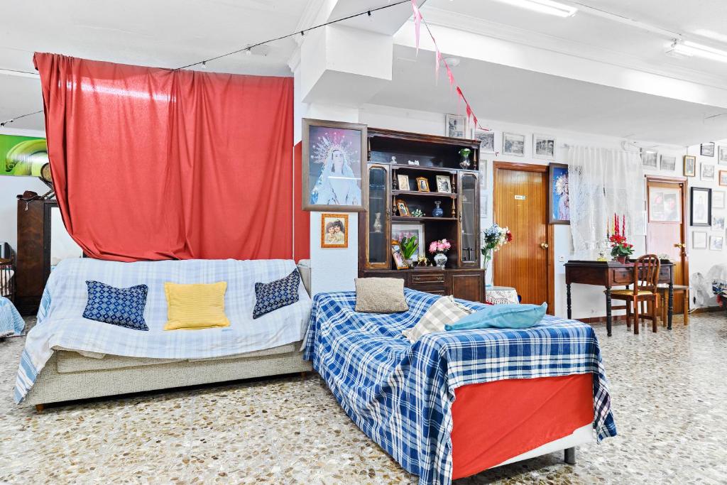ein Schlafzimmer mit zwei Betten und einem roten Vorhang in der Unterkunft Alojamiento para Grupos y Empresas Hasta 14 Personas Ideal Equipos y Familias in Lorca